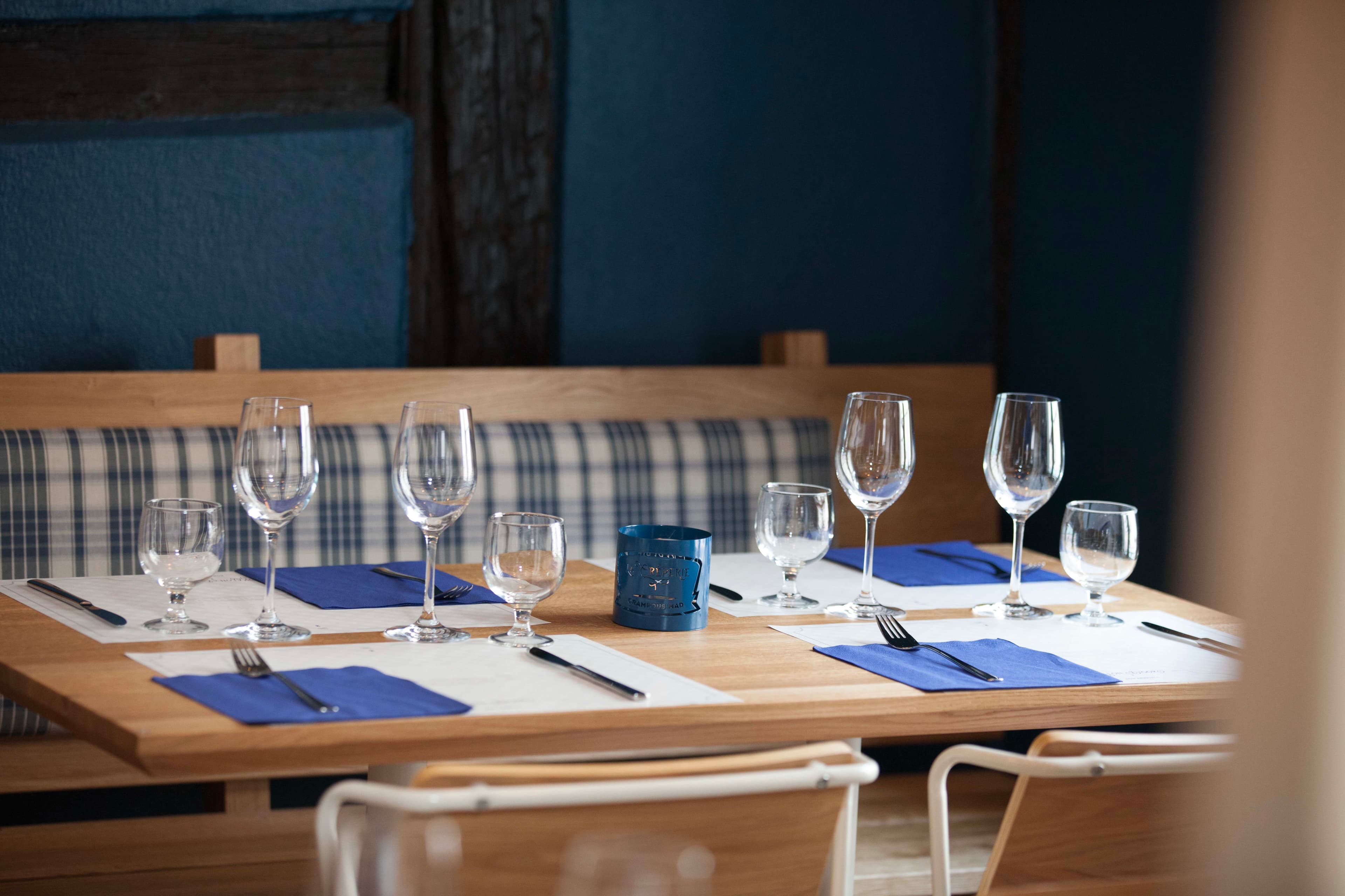 Verres et serviettes bleues sur une table de la crêperie Crampous Mad